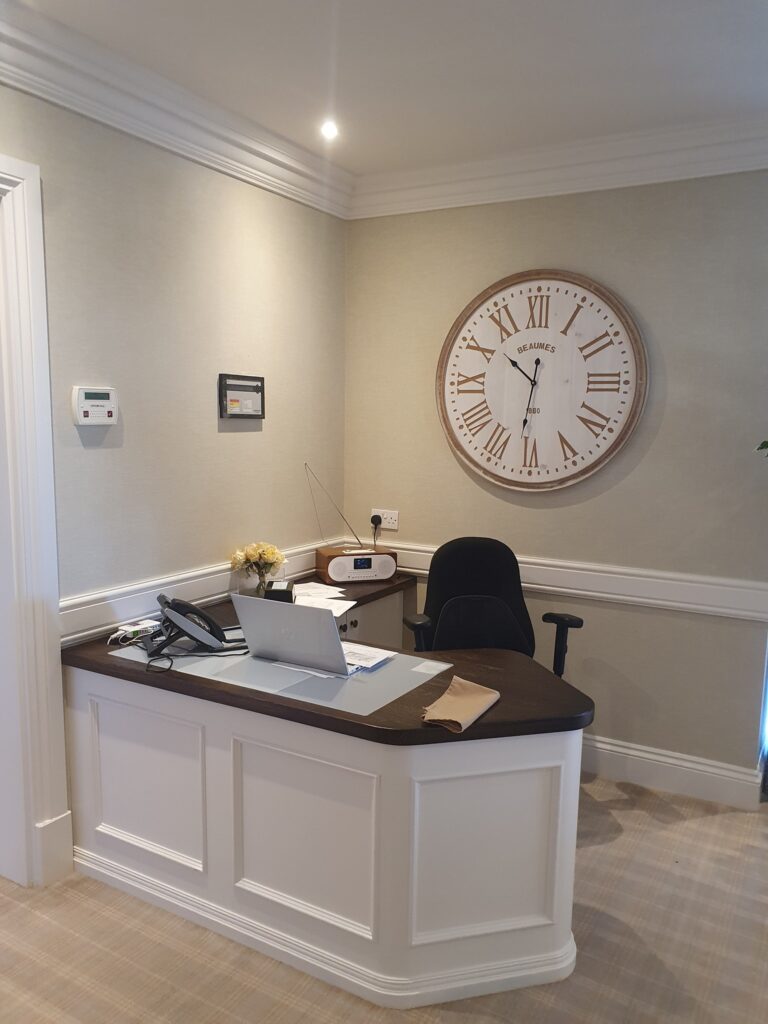 Desk with clock on wall behind
